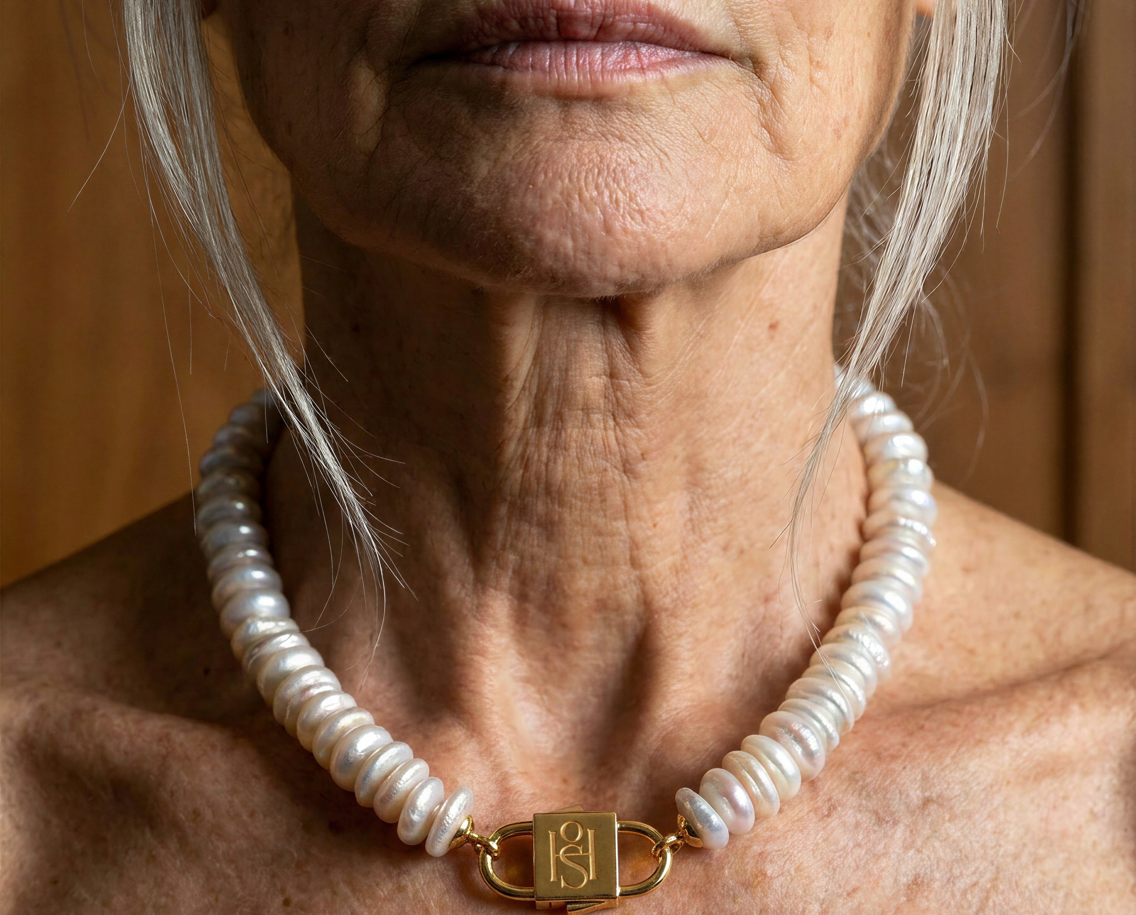 Fahrelnissa freshwater disc pearl necklace with engraved gold lock clasp by House of Sól, worn by silver-haired model.
