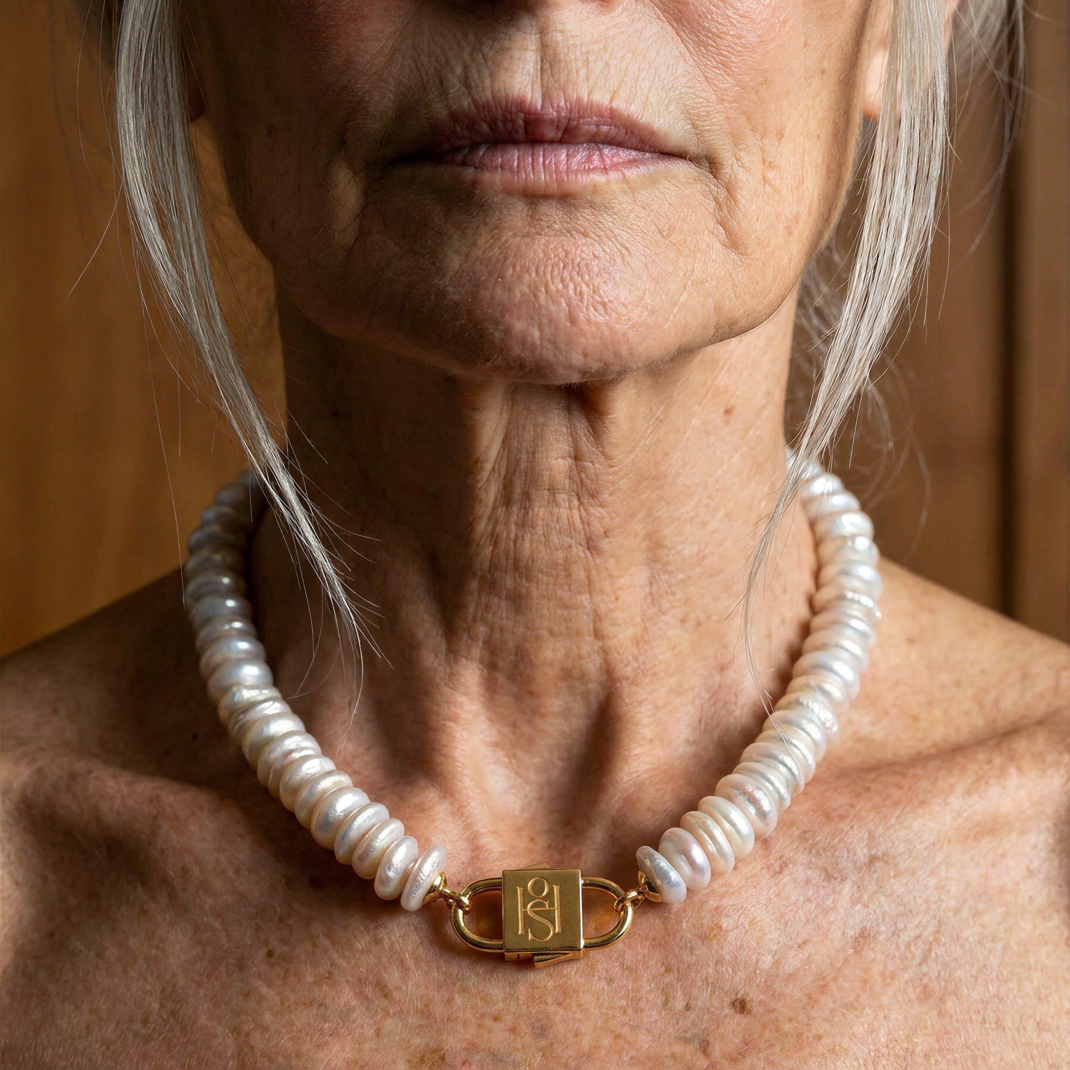 Fahrelnissa freshwater disc pearl necklace with engraved gold lock clasp by House of Sól, worn by silver-haired model.