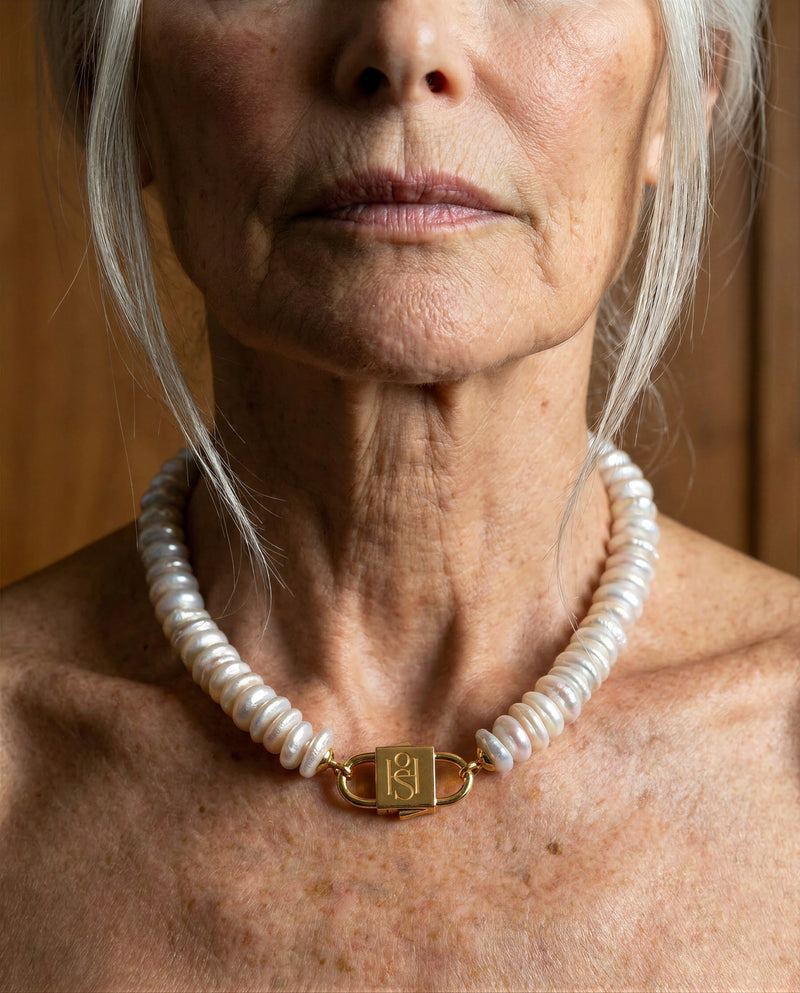 Fahrelnissa freshwater disc pearl necklace with engraved gold lock clasp by House of Sól, worn by silver-haired model.