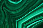 Close-up of green malachite with curved concentric bands, a material reference for the Anohni necklace