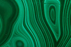 Close-up of green malachite with wavy bands and oval eye patterns, a material reference for the Anohni necklace