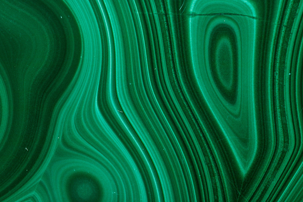 Close-up of green malachite with wavy bands and oval eye patterns, a material reference for the Anohni necklace