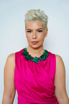 Anohni malachite necklace on model in a pink sleeveless dress, front view on a light backdrop