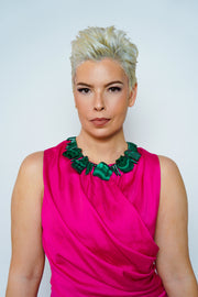 Anohni malachite necklace on model in a pink sleeveless dress, front view on a light backdrop