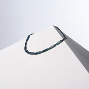 Bebe Noir peacock gray Biwa pearl necklace draped over a white block, HoS Lock out of view