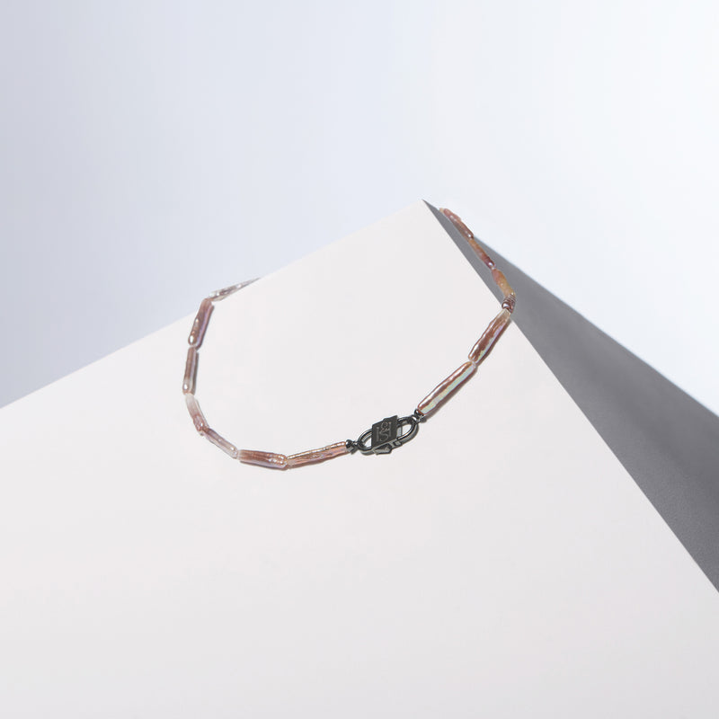 Bebe Rose pink Biwa pearl necklace closed with black HoS Lock on a white block