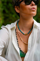 Bebe Turquoise necklace with HoS Lock layered with two longer beaded necklaces, open white shirt