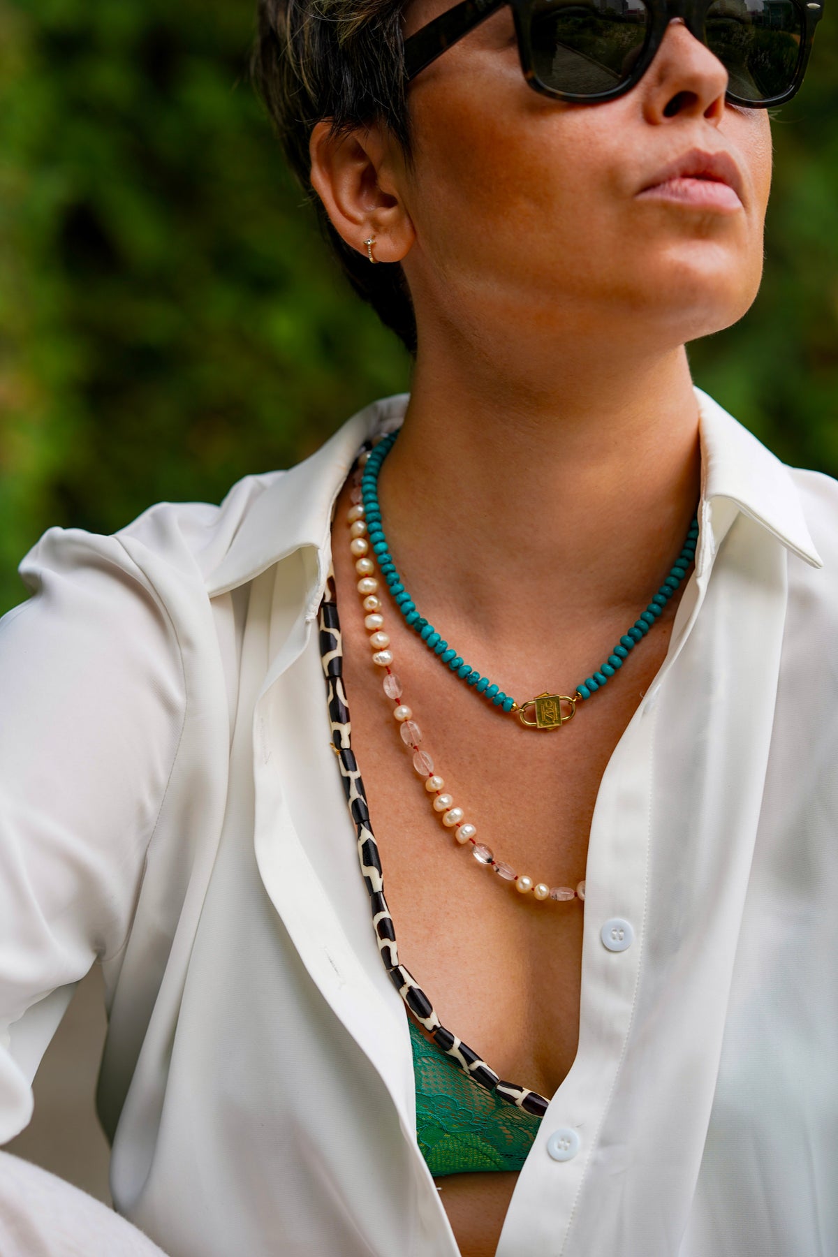 Bebe Turquoise necklace with HoS Lock layered with two longer beaded necklaces, open white shirt