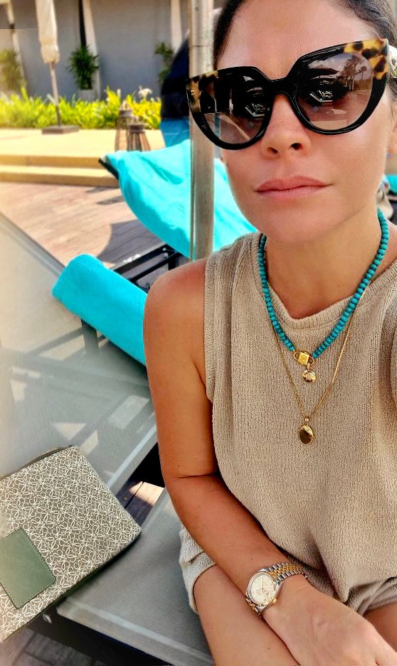 Bebe Turquoise necklace with HoS Lock worn poolside, plus a small charm and a gold-tone pendant necklace