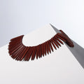 Bitter Only howlite necklace of long tapered beads fanned into a collar on a white block