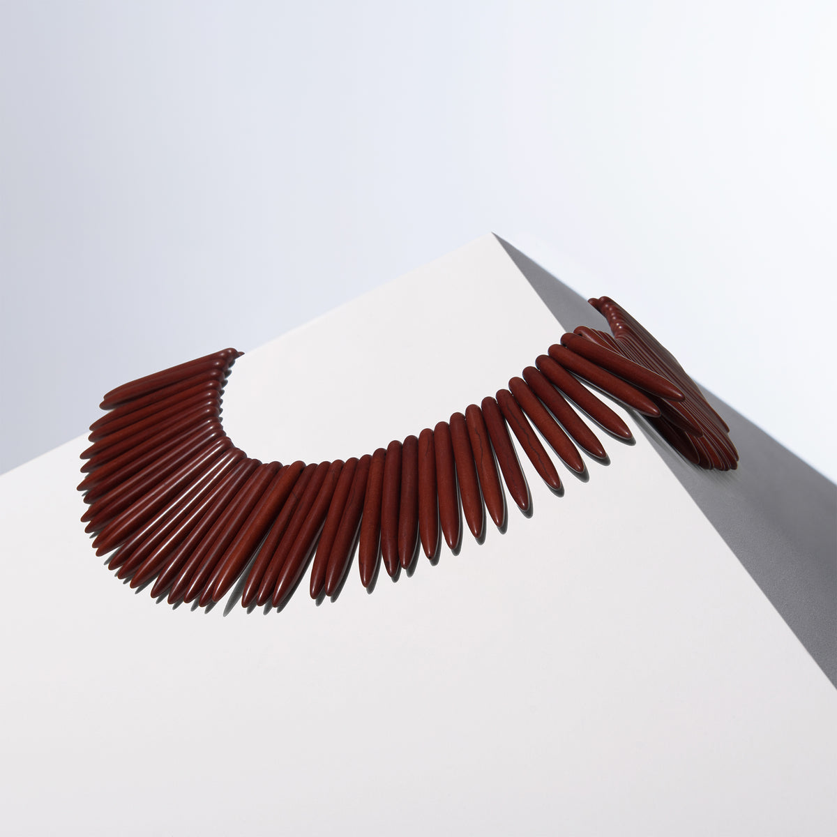 Bitter Only howlite necklace of long tapered beads fanned into a collar on a white block