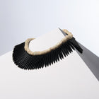 Black Nefertiti white coral and black howlite spike necklaces draped together over a white block