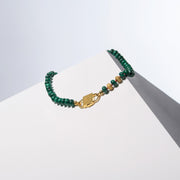 Iris malachite rondelle necklace with gold-filled ornaments and gold-tone HoS Lock on a white block