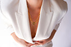 Medium Trombone Chain Necklace with HoS Lock at the neckline of a white blazer, close-up
