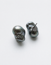 Perle Noire peacock baroque pearl earrings, one turned to show its monogrammed black rhodium plated back