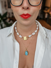 Scarab charm on a fine chain worn below a baroque pearl necklace with HoS Lock