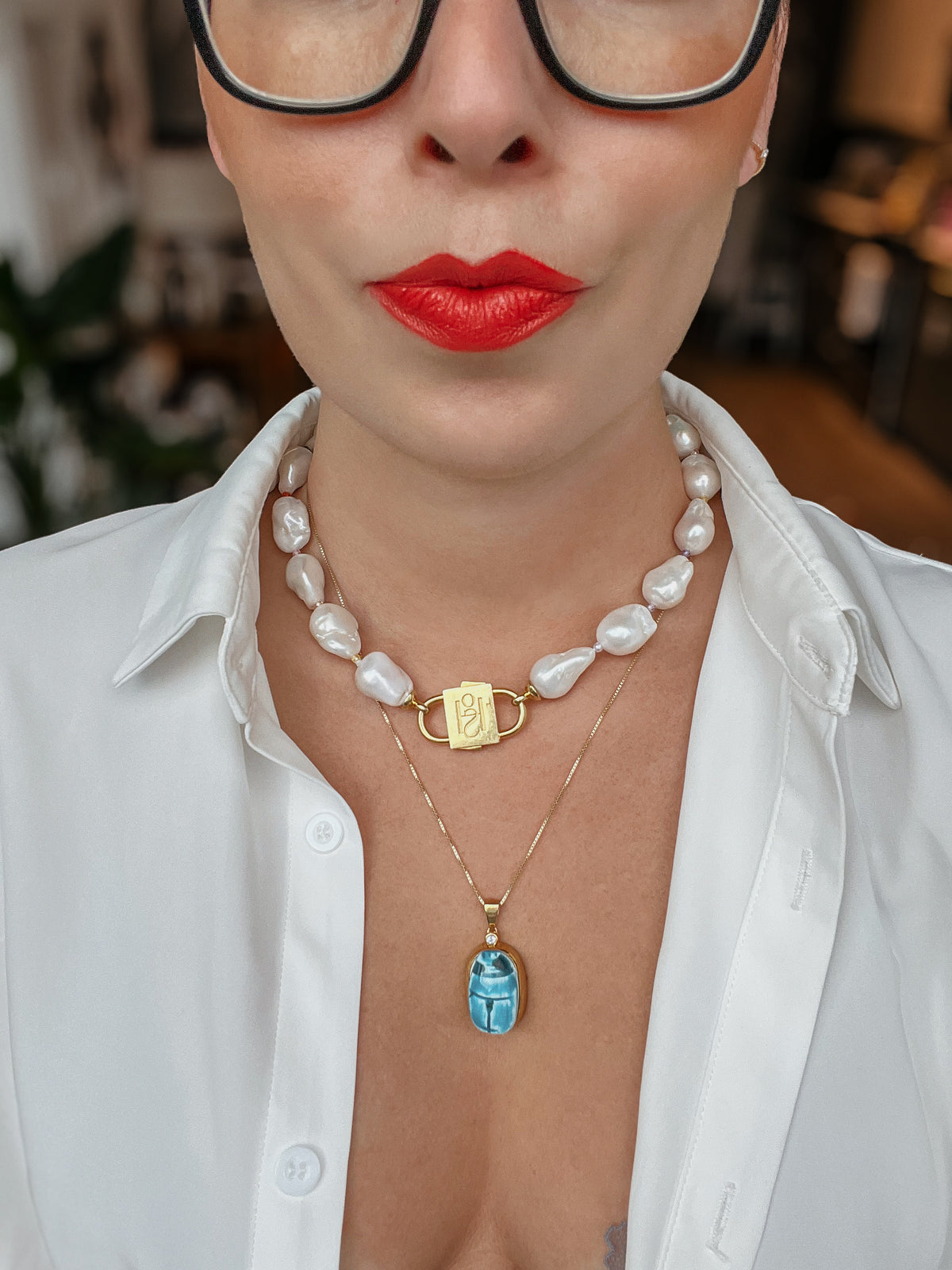 Scarab charm on a fine chain worn below a baroque pearl necklace with HoS Lock