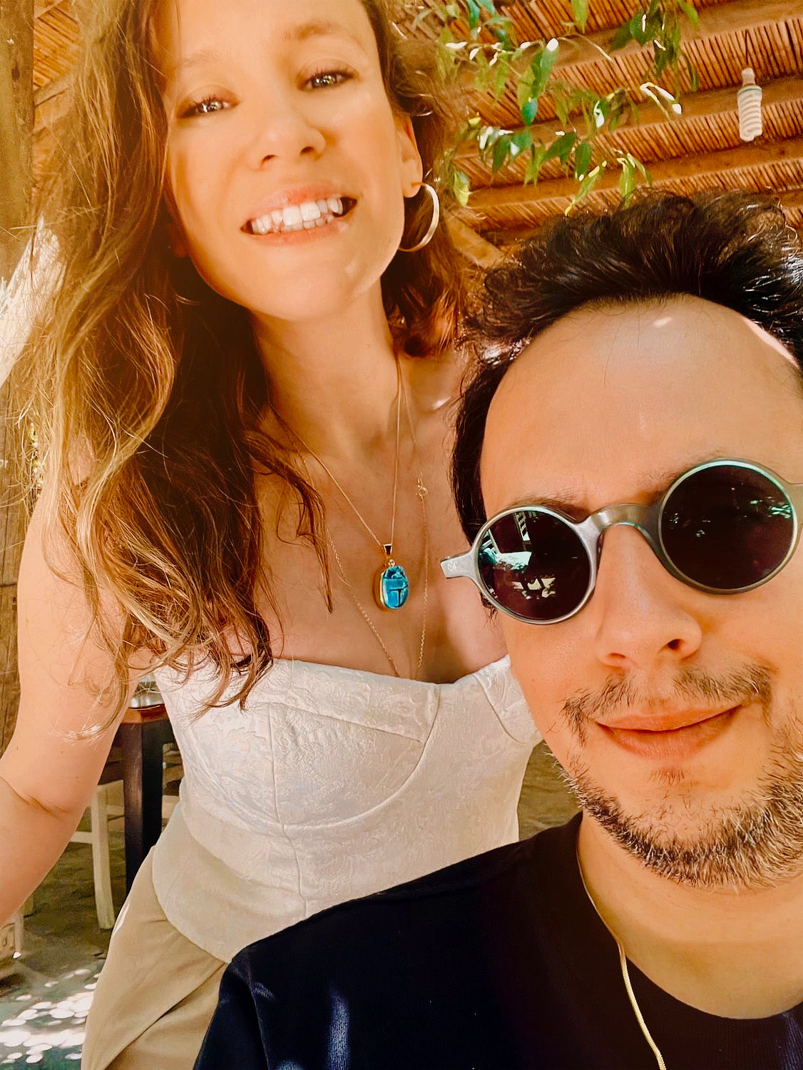 Woman wearing the Scarab charm on a fine chain in a selfie with a man in sunglasses
