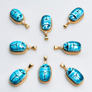 Eight Scarab charms of blue Egyptian faience with white sapphires arranged in a ring