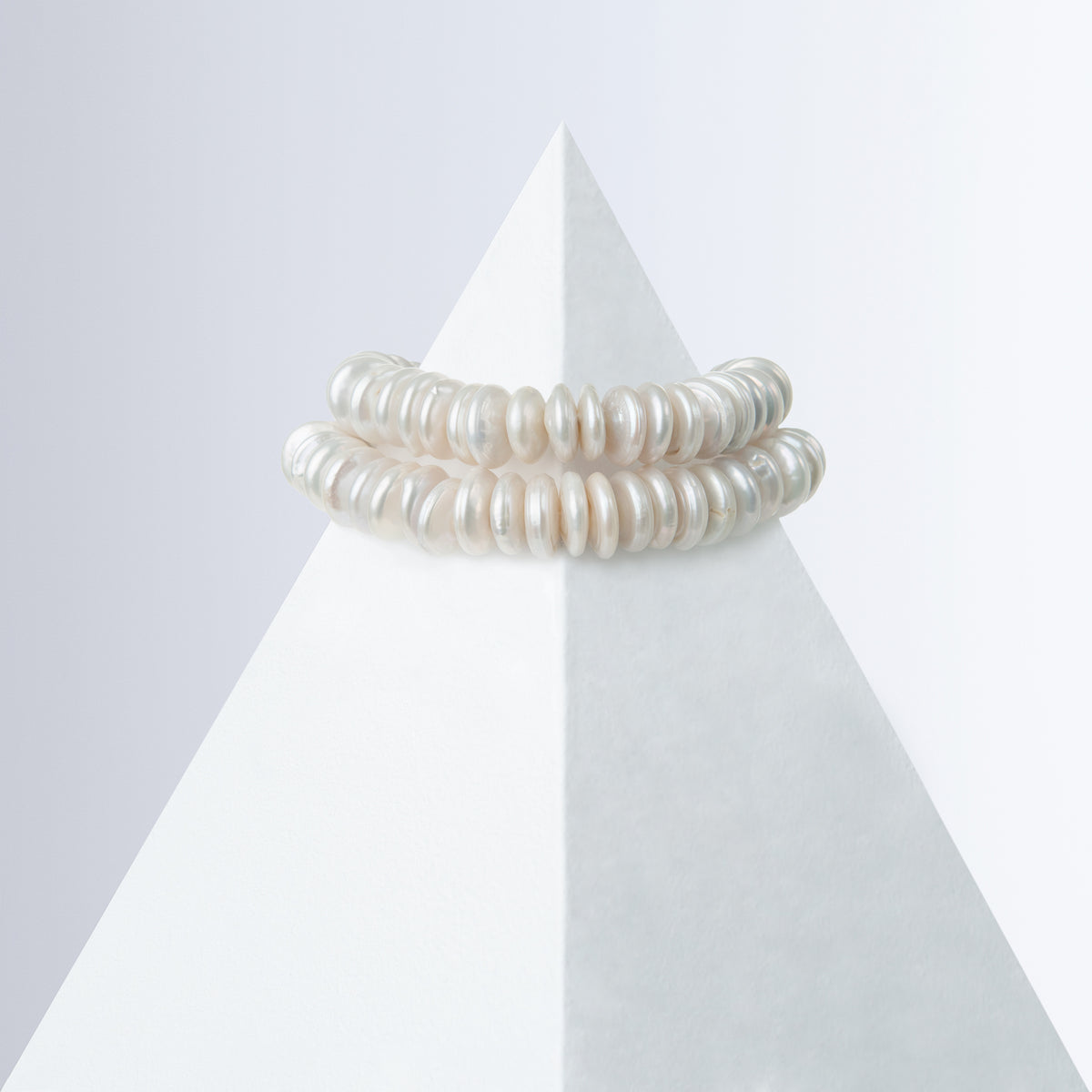 Shirin rondelle pearl bracelet styled as a double line on a white pyramid, back view