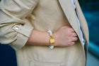 Shirin rondelle pearl bracelet with gold-tone HoS Lock on a wrist resting against a beige blazer