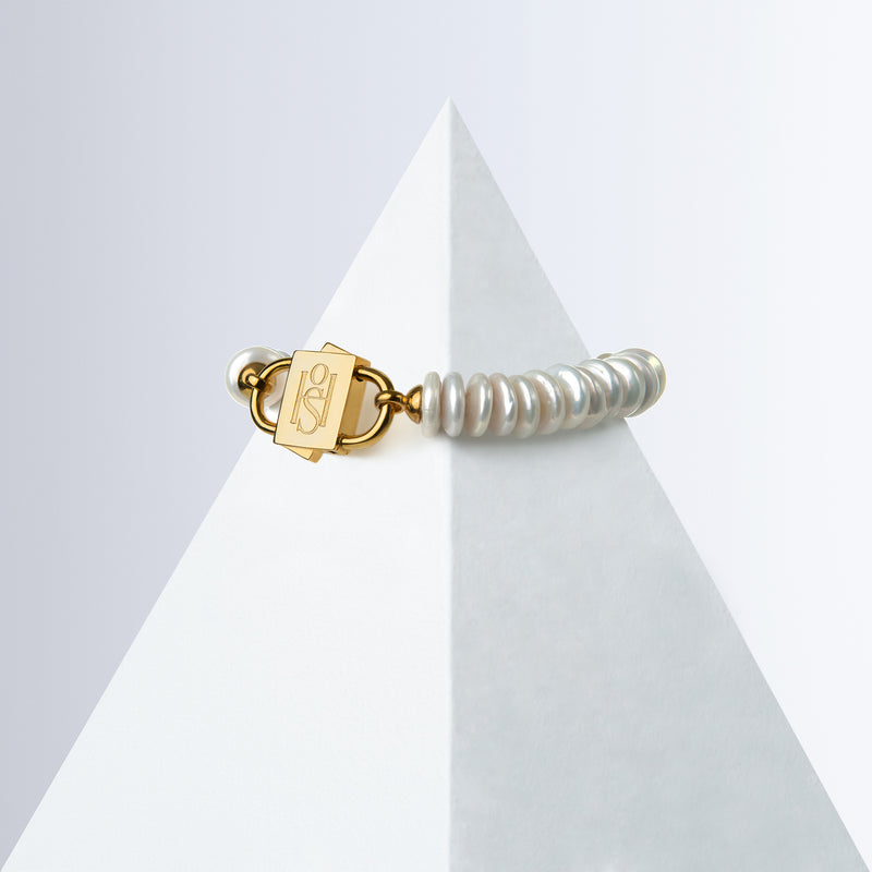 Shirin rondelle pearl bracelet with gold-tone HoS Lock on a white pyramid