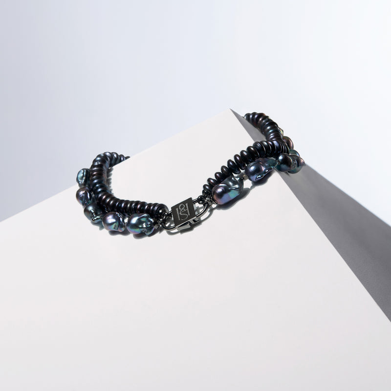 Simone peacock gray baroque and rondelle pearl strands joined by the HoS Lock on a white block