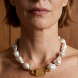Ostrea baroque pearl necklace with House of Sól signature gold lock clasp, worn by brunette model with short bob cut