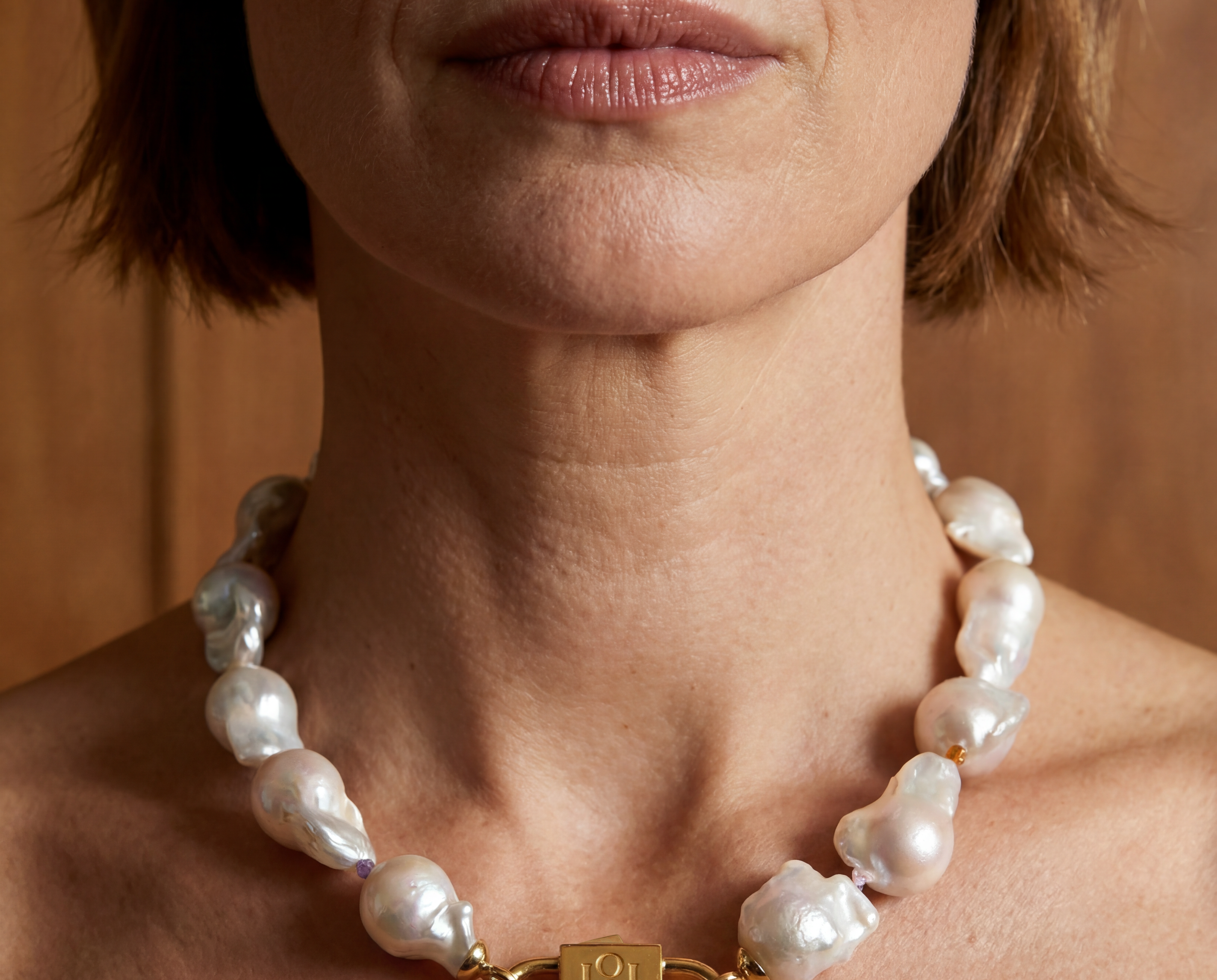 Ostrea baroque pearl necklace with House of Sól signature gold lock clasp, worn by brunette model with short bob cut