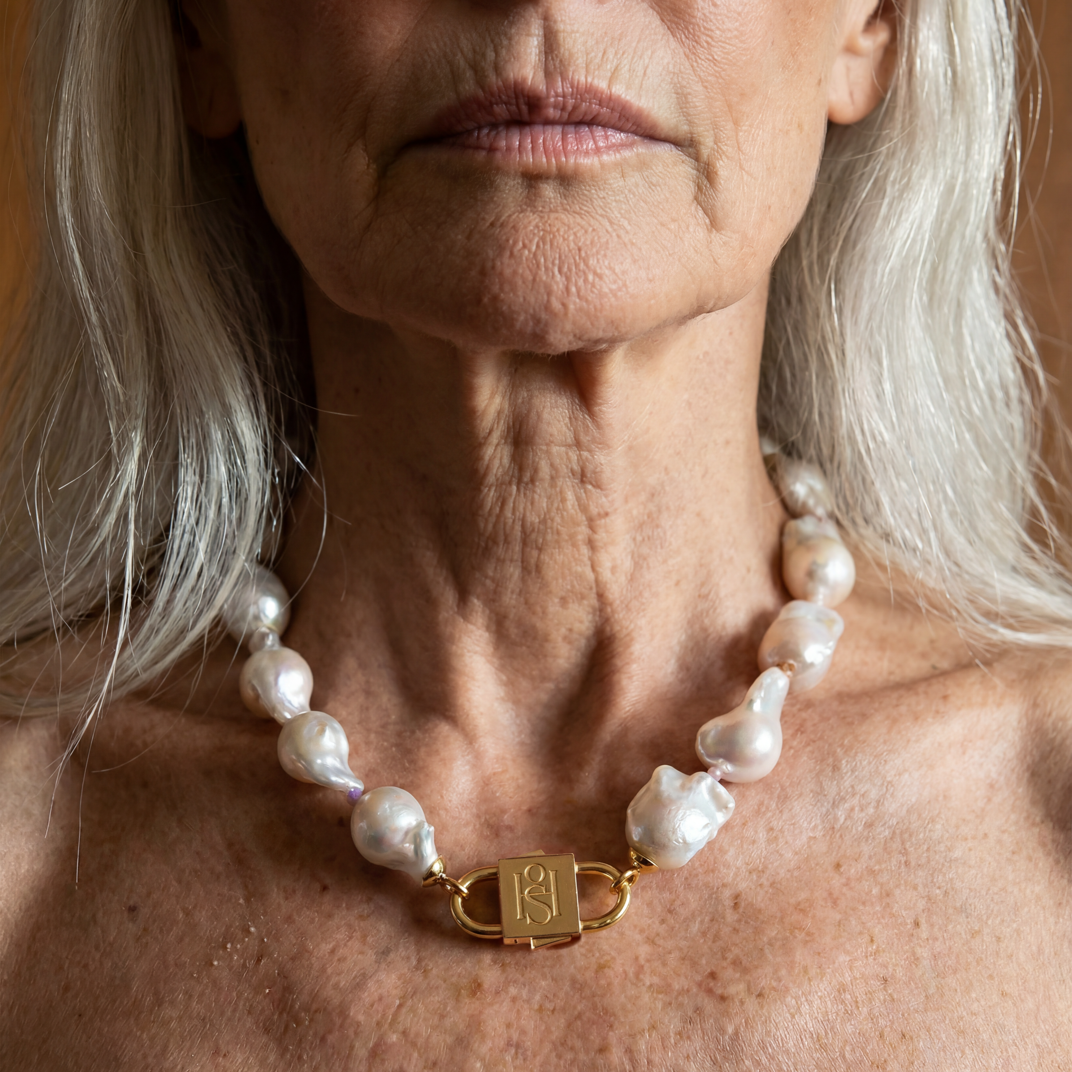 Ostrea baroque pearl necklace with engraved gold lock clasp by House of Sól, worn by silver-haired model.