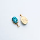 Two Scarab charms side by side, one showing the faience front and one the HoS monogram back