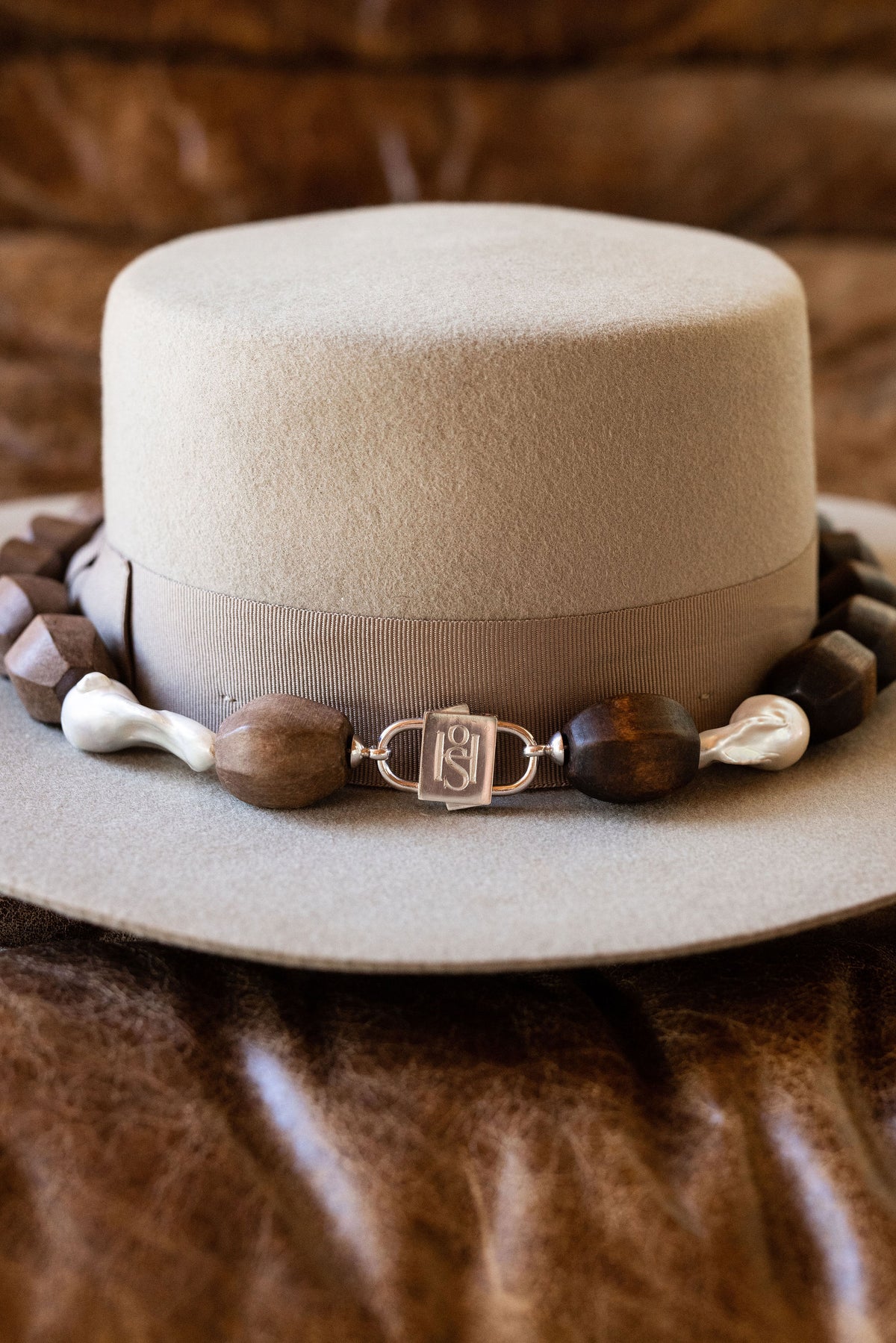 Light Walden necklace wrapped around a hat, joined by HoS Lock to a separate darker wood strand