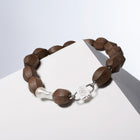 Light Walden light brown wood and baroque pearl necklace with a silver-tone HoS Lock on a white block