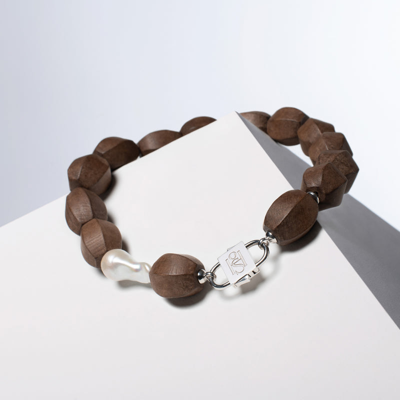 Light Walden light brown wood and baroque pearl necklace with a silver-tone HoS Lock on a white block