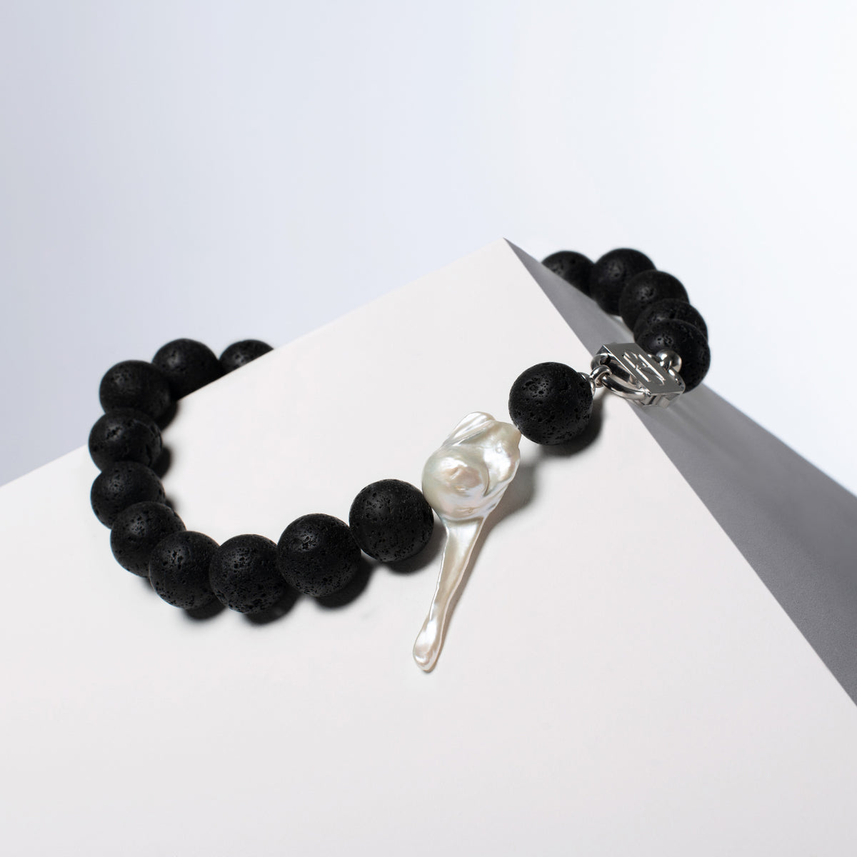 Luna necklace turned to show the baroque pearl and lava stones, HoS Lock seen side-on