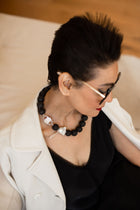 Luna necklace with HoS Lock and baroque pearl seen over the model's shoulder