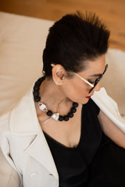 Luna necklace with HoS Lock and baroque pearl seen over the model's shoulder
