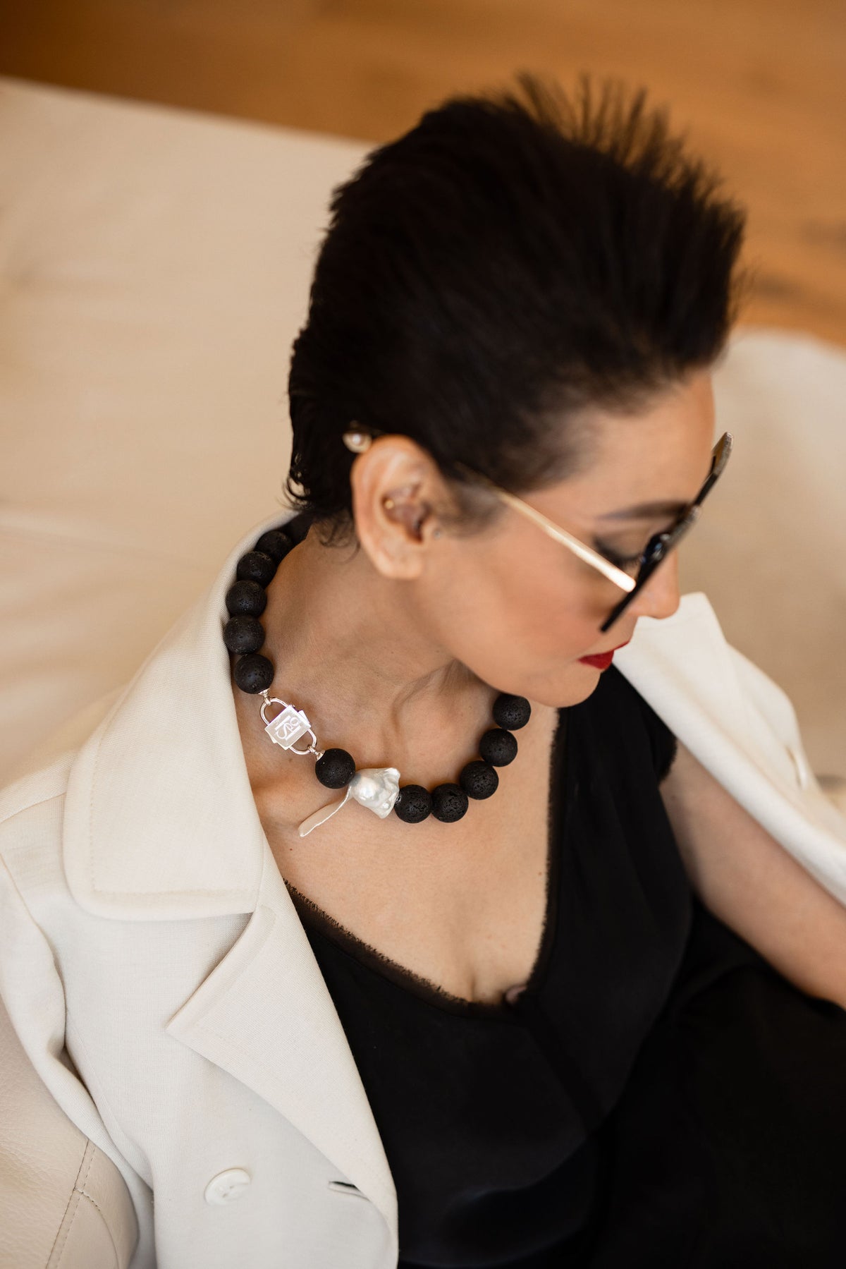 Luna necklace with HoS Lock and baroque pearl seen over the model's shoulder