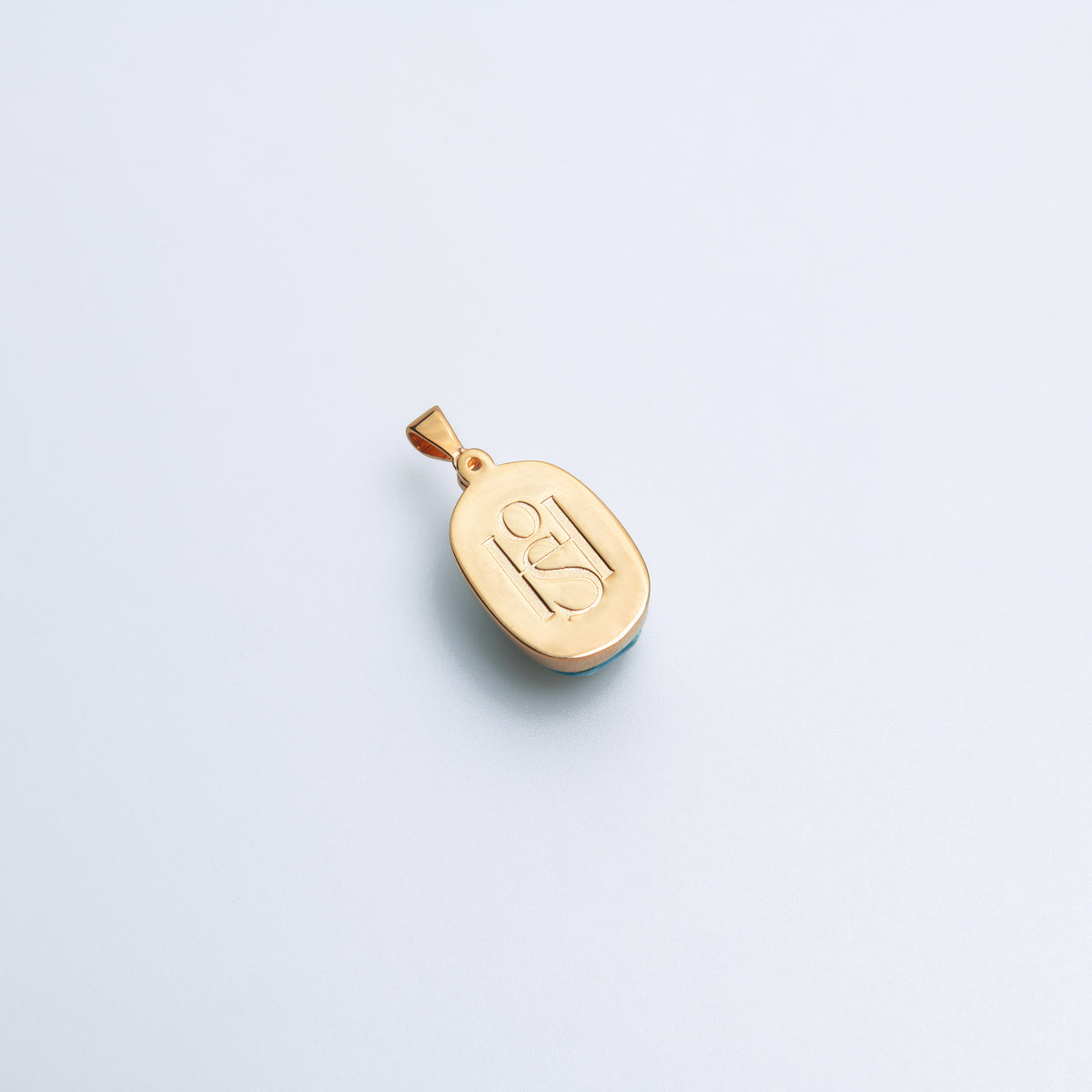 Back of the Scarab charm showing the HoS monogram on a white background