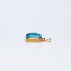 Side view of the Scarab charm showing its faience top, white sapphire and bail