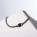 Siren - I black pearl necklace with a black rhodium sterling silver HoS Lock on a white block