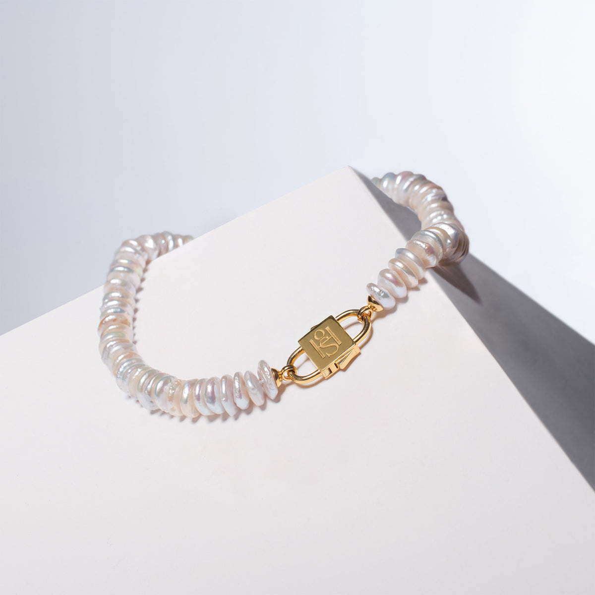 Fahrelnissa pearl necklace with a gold  House of Sol clasp, named after the artist Fahrelnissa Zeid, displayed on a white surface.